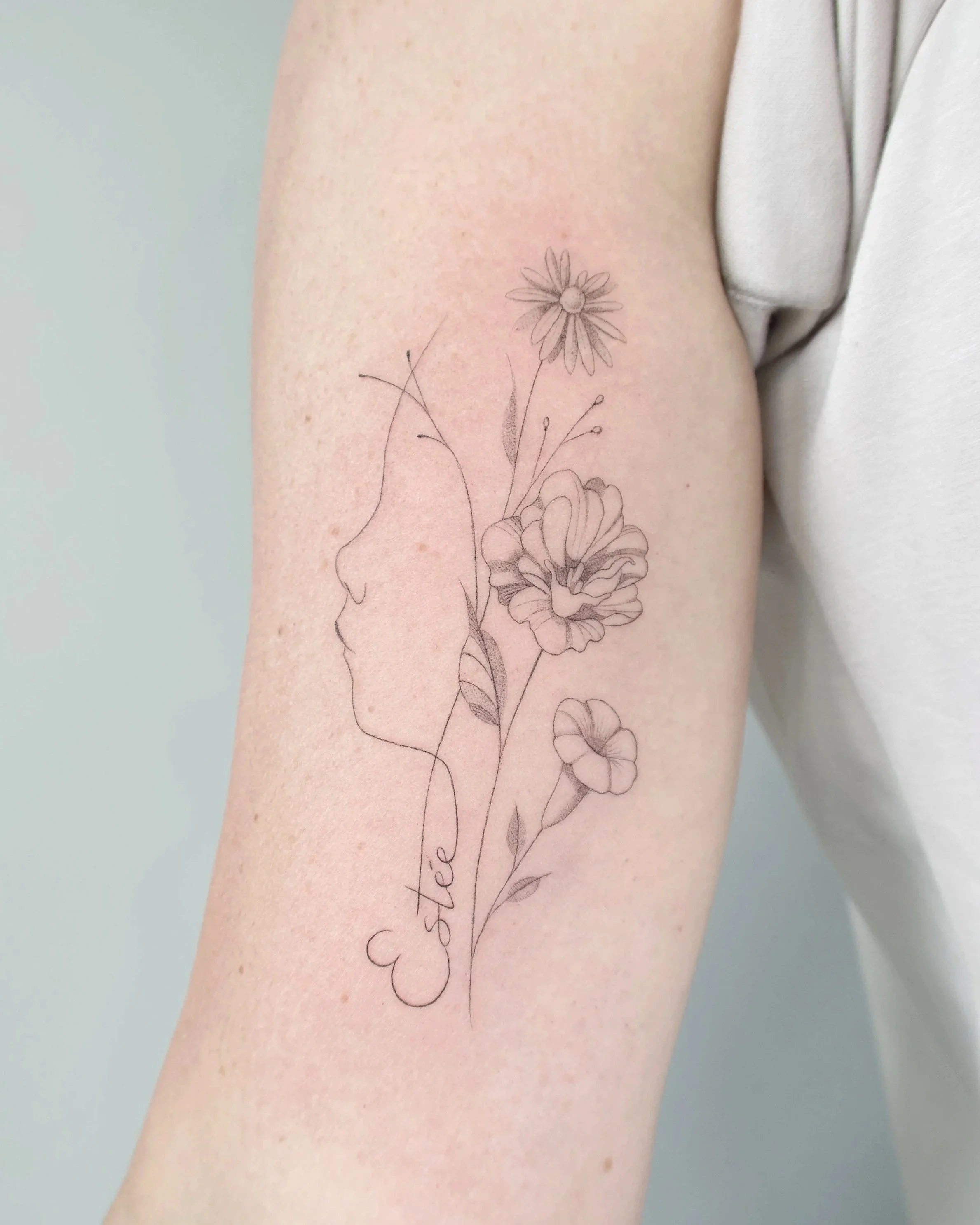 profiel kindje met geboortebloemen fineline tattoo