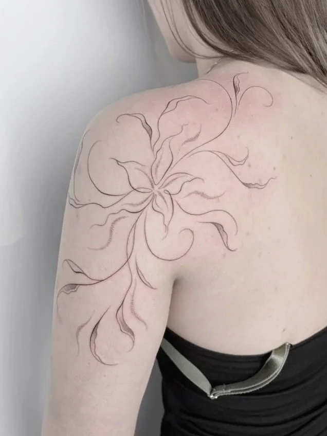 abstracte lelie bloem met bladeren schouder tattoo fineline