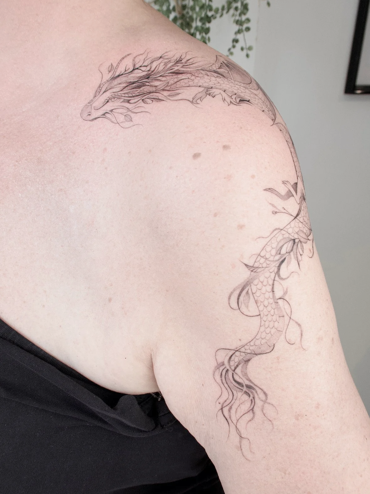 draak rondom schouder fineline tattoo 
