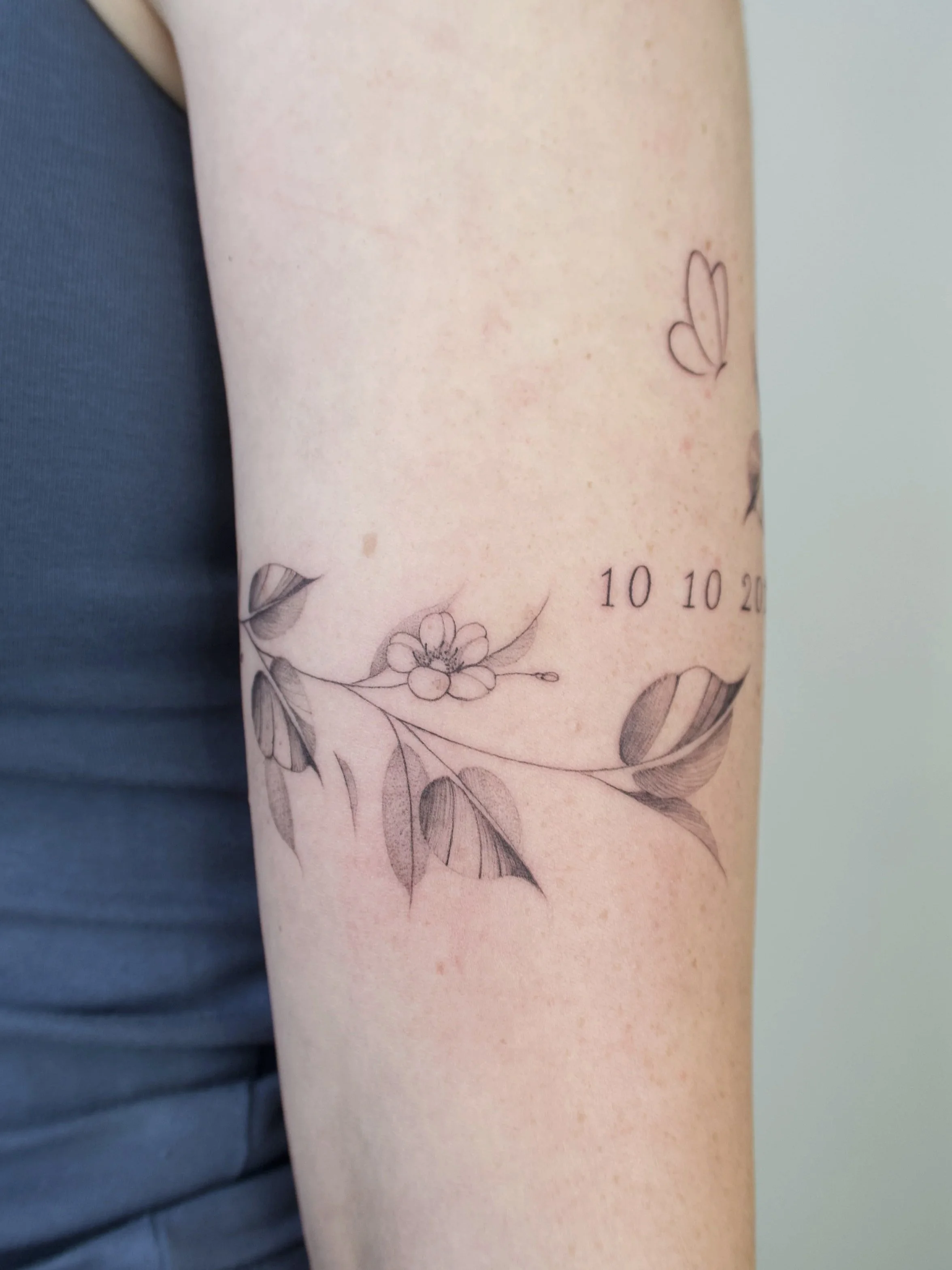 flow fineline bladeren met bloemen rondom arm 