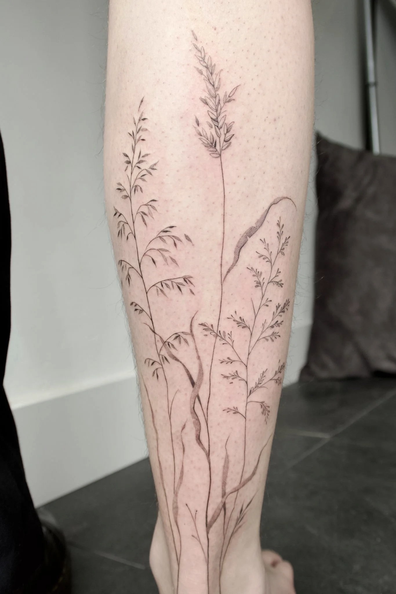 wilde grassen op onderbeen tattoo fineline