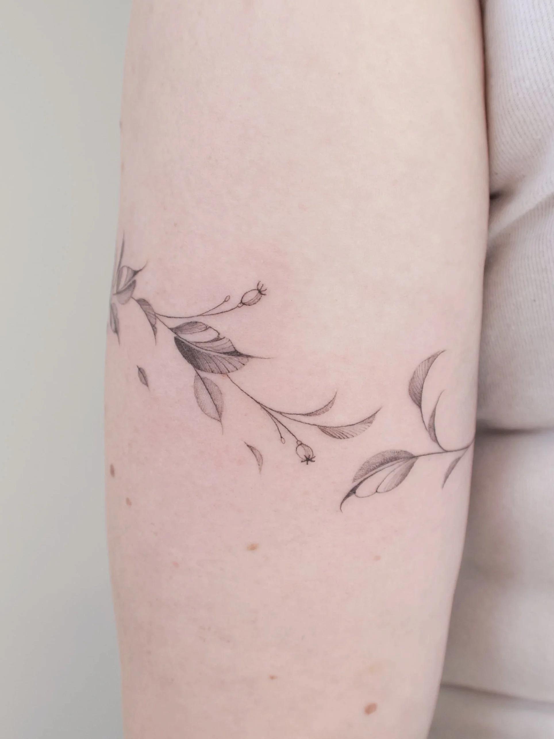 flow fineline bladeren met bloemen rondom arm 