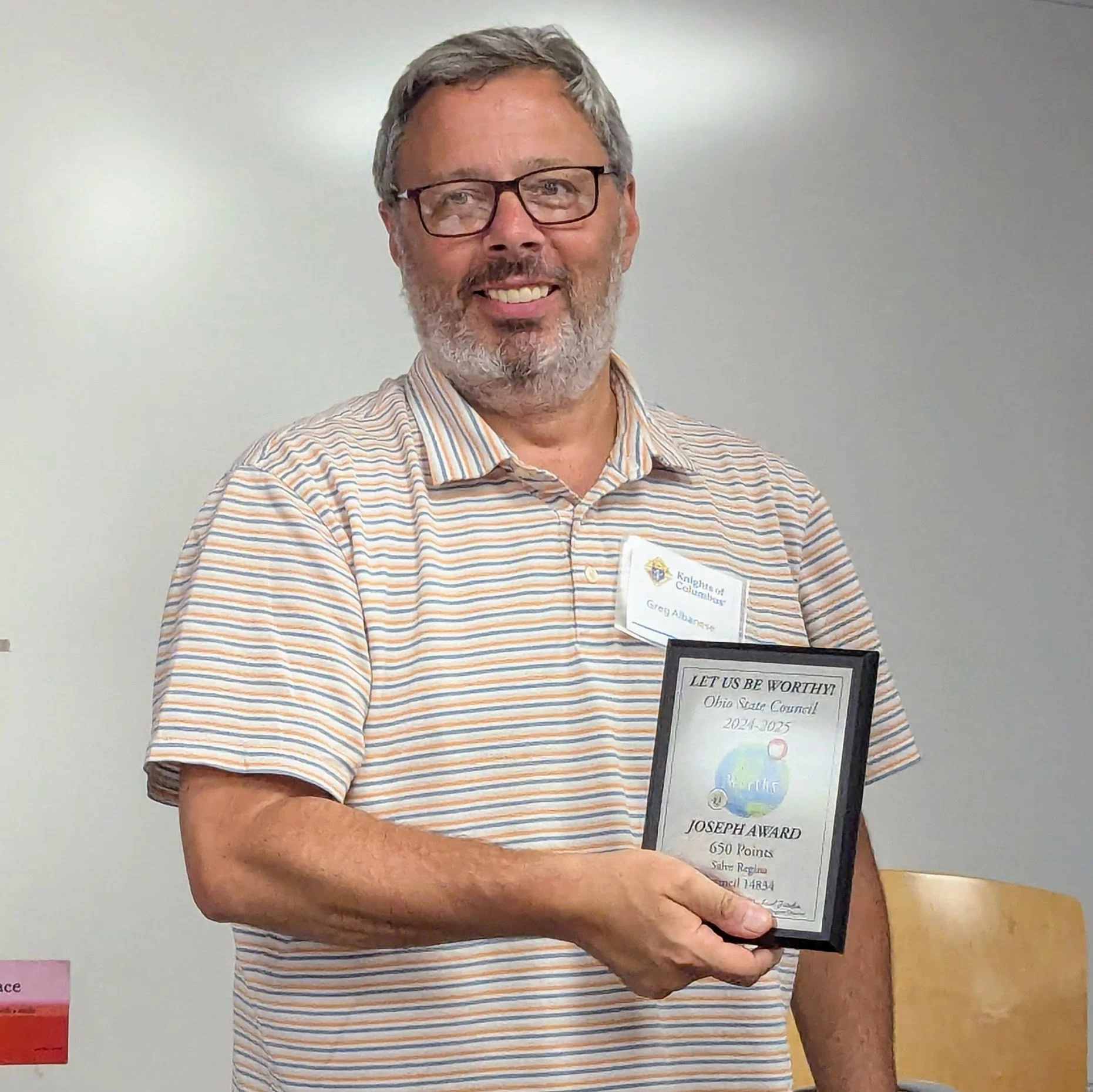 Program Director SK Greg Albanese accepts the award for Salve Regina for completion of service programs that accumulated 650 points.
