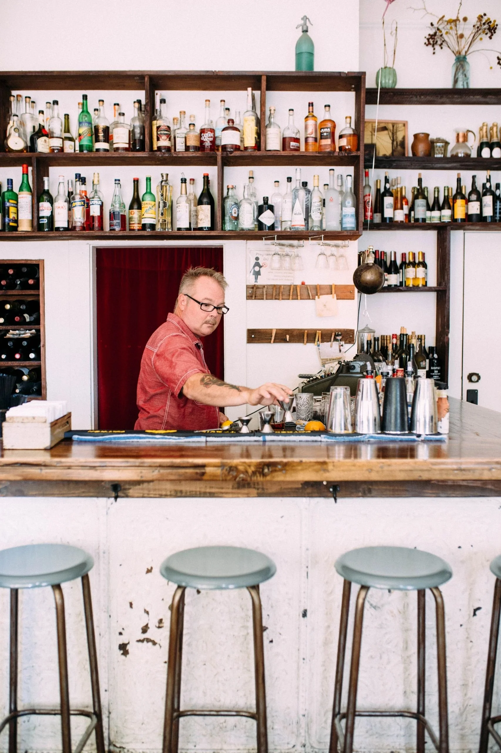Bartender, owner Patrick preparing for bar service at Thistle Restaurant