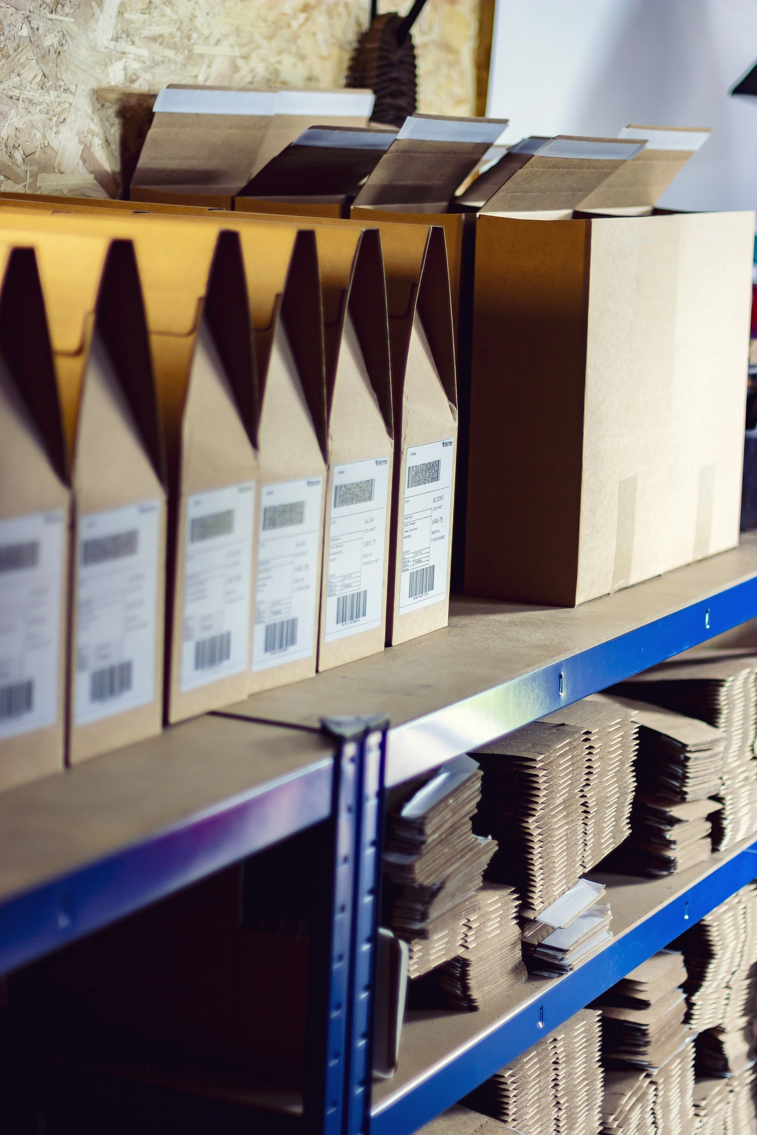 Shelves with cardboard packages and folders in a storage area.
