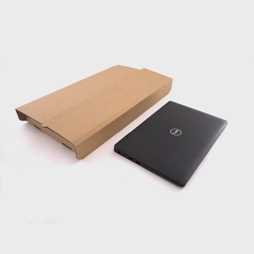 A black closed Dell laptop next to a plain brown cardboard box on a white surface.