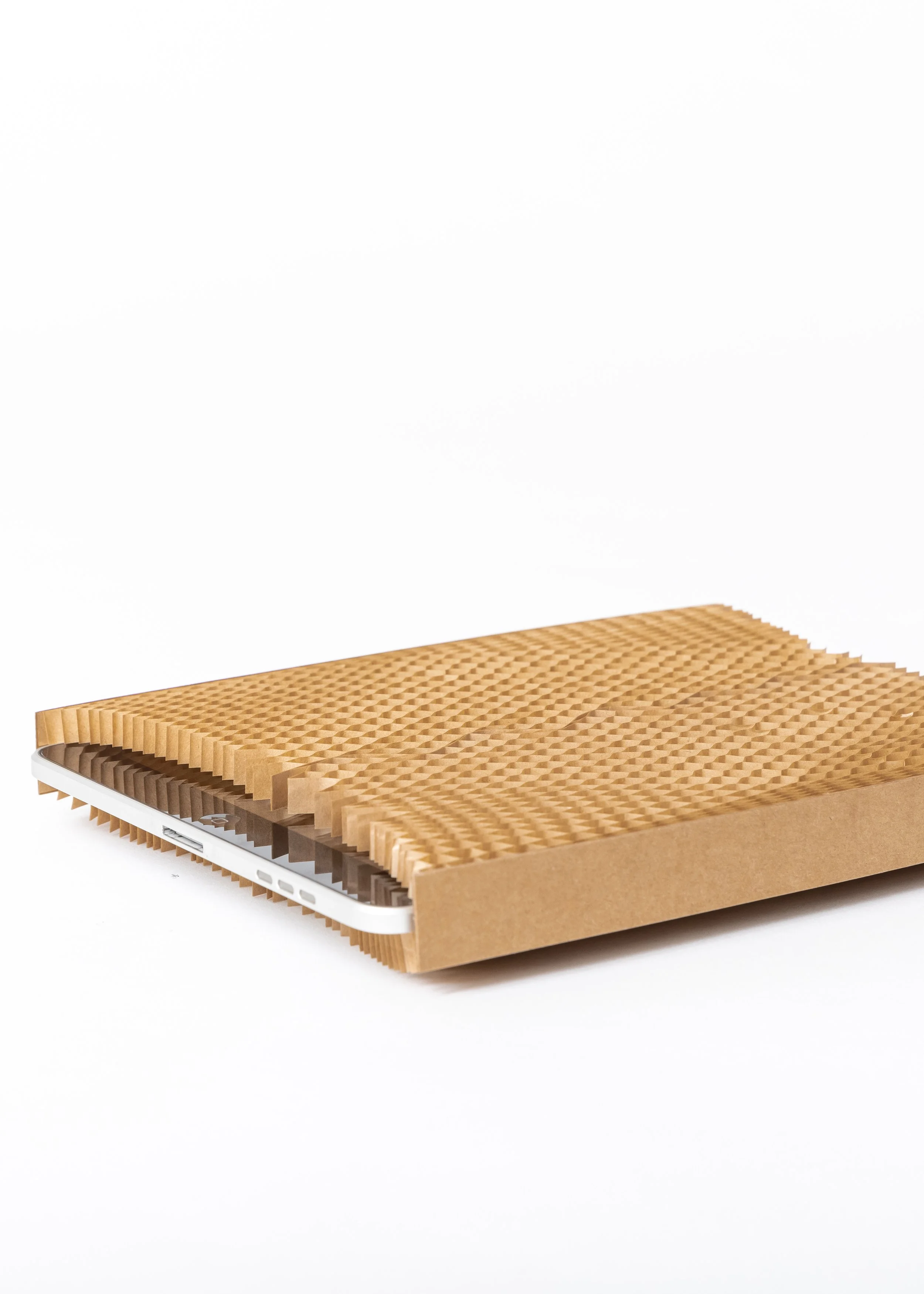 A corrugated cardboard sleeve partially covering a tablet or e-reader on a white background.