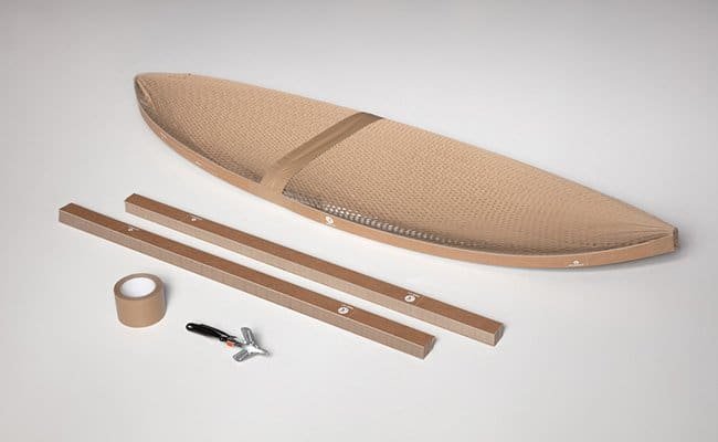 Cardboard kayak assembly kit with hull, two strips, duct tape, and a multitool on a gray background.