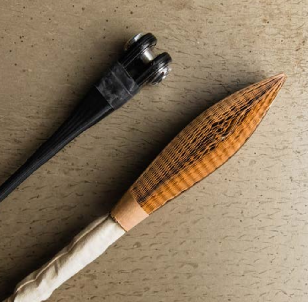 Traditional chiurin and kabukikuji Japanese tea ceremony tools on a textured surface.