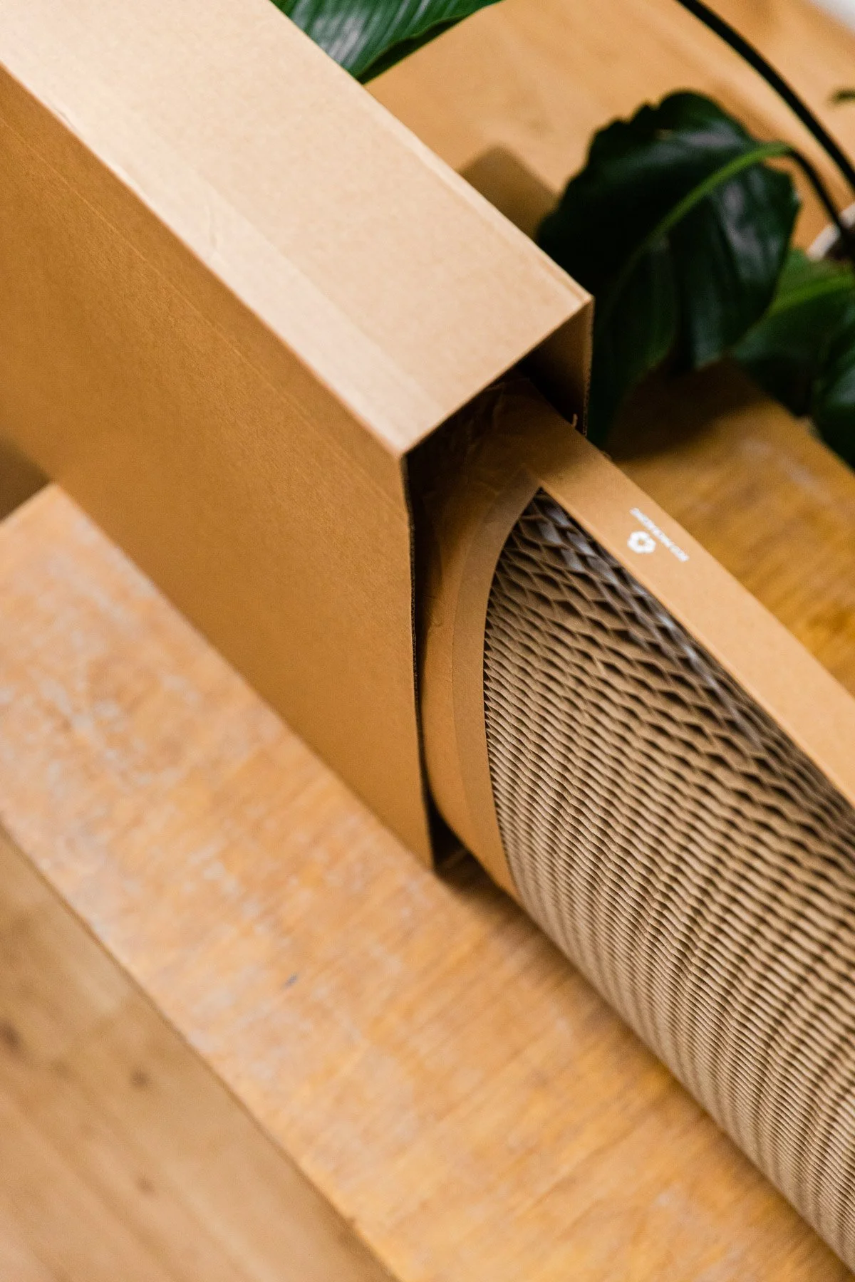 Cardboard box with honeycomb paper packing material on a wooden surface.