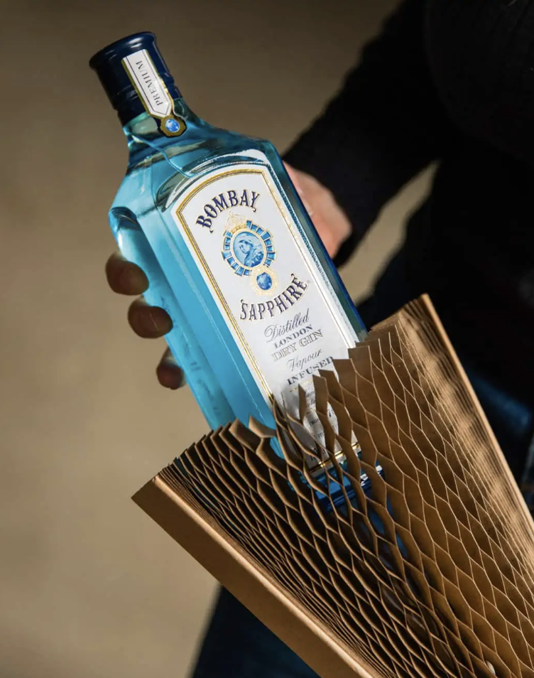 Bombay Sapphire gin bottle held by a person in brown packaging