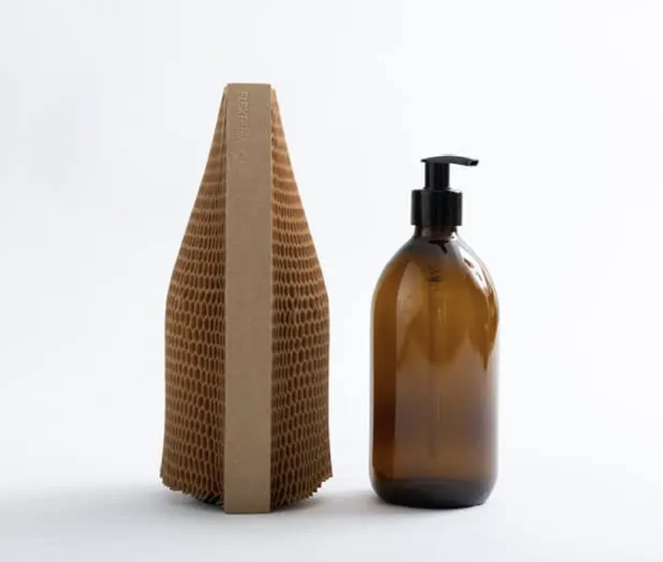 Brown pump bottle with honeycomb cardboard packaging on white background.