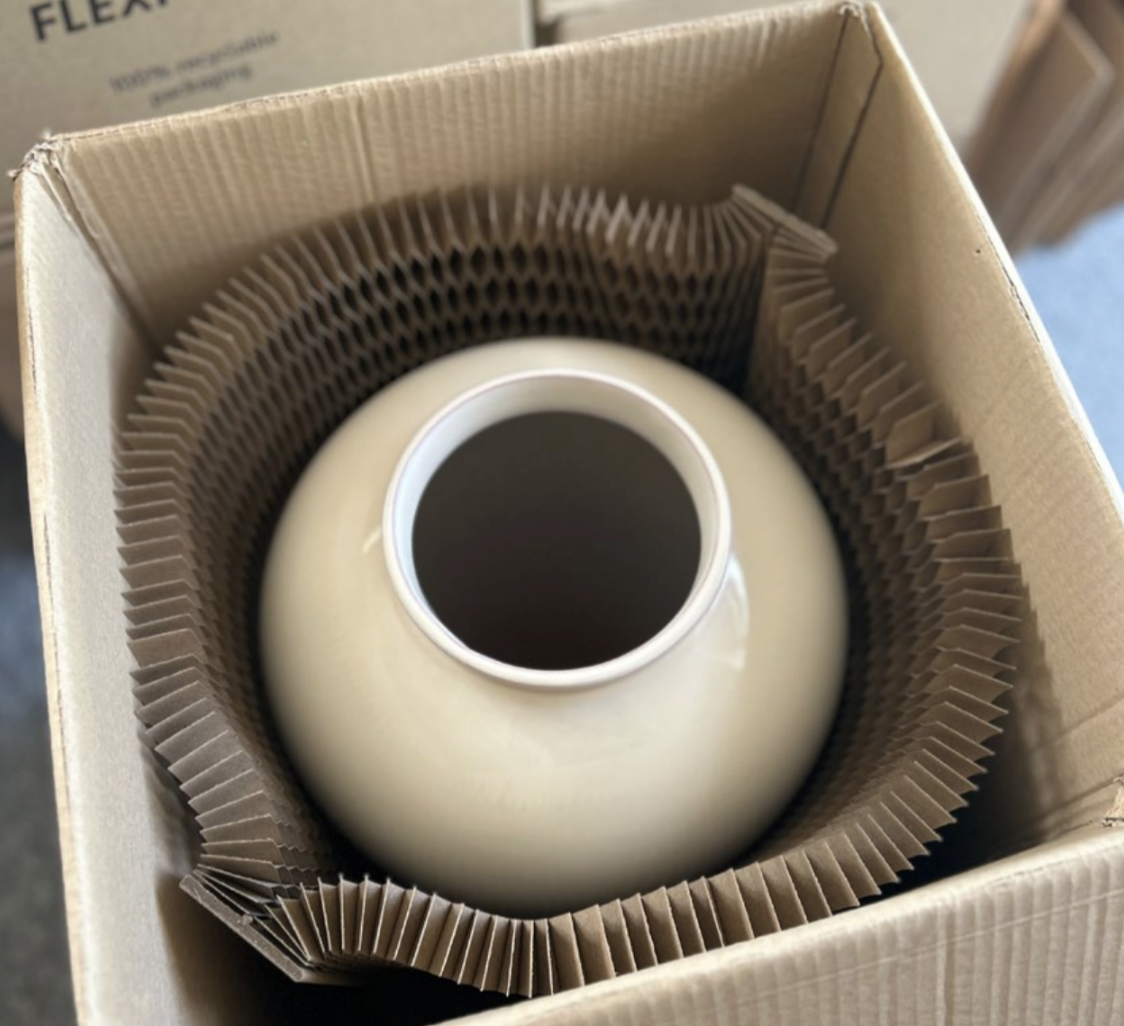 Vase packed in a cardboard box with honeycomb paper padding.