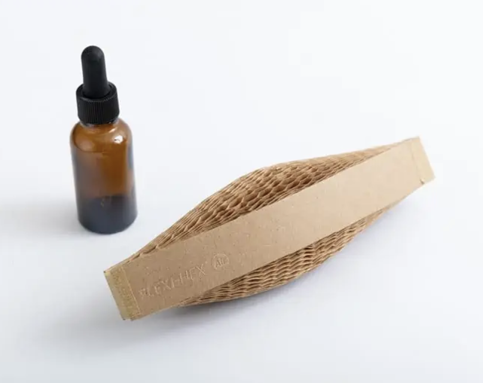 Brown glass dropper bottle next to a textured cardboard sleeve on a white background.