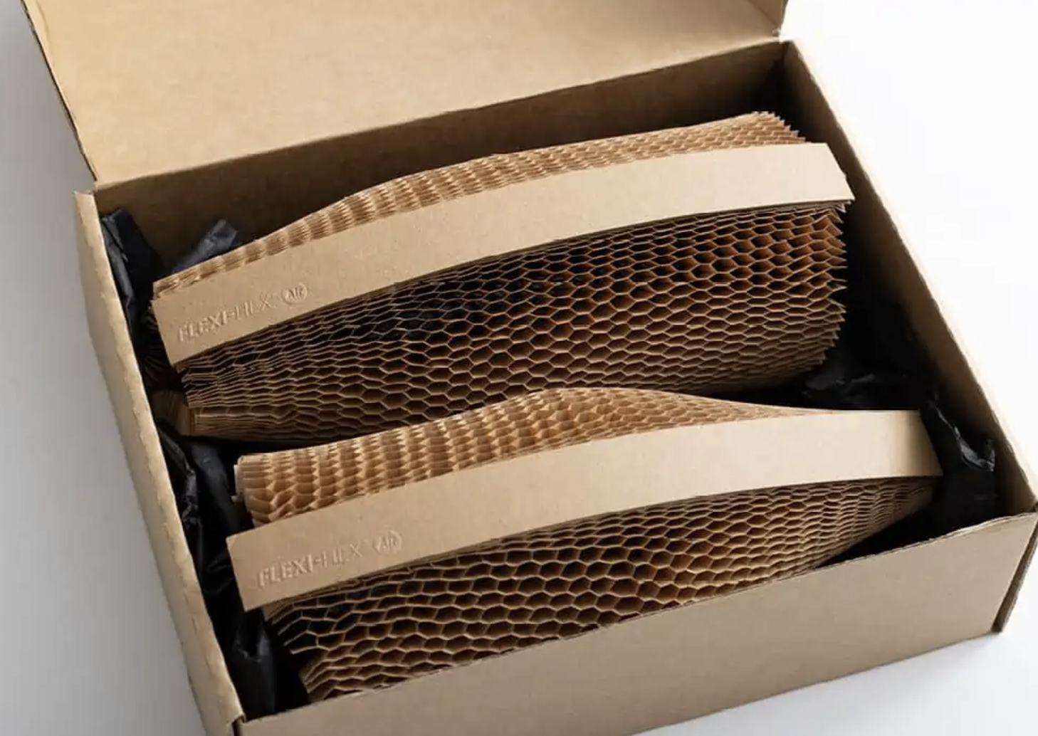 Cardboard box containing two brown honeycomb paper cylinders for packaging.