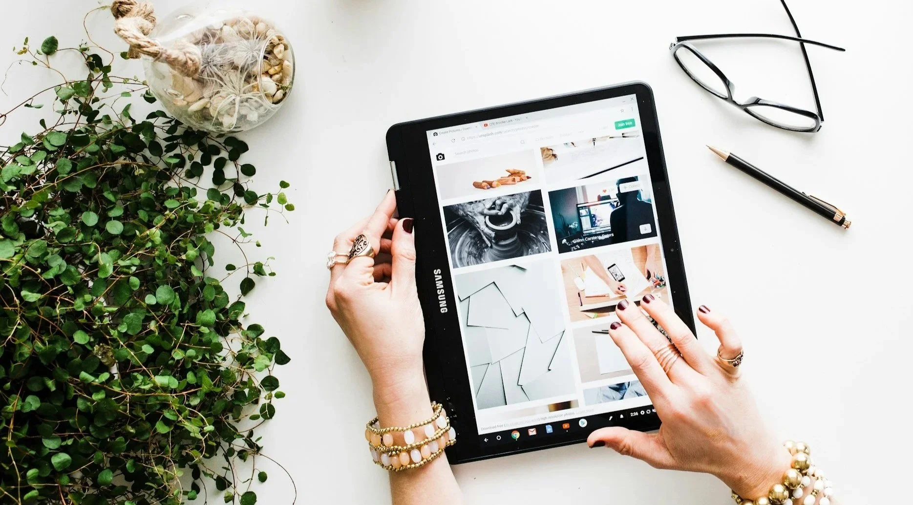 Hand with jewellery working on an Ipad.