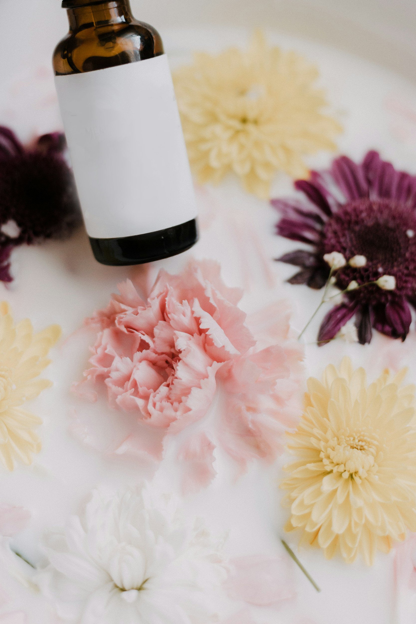Bottle over flowers in milk bath