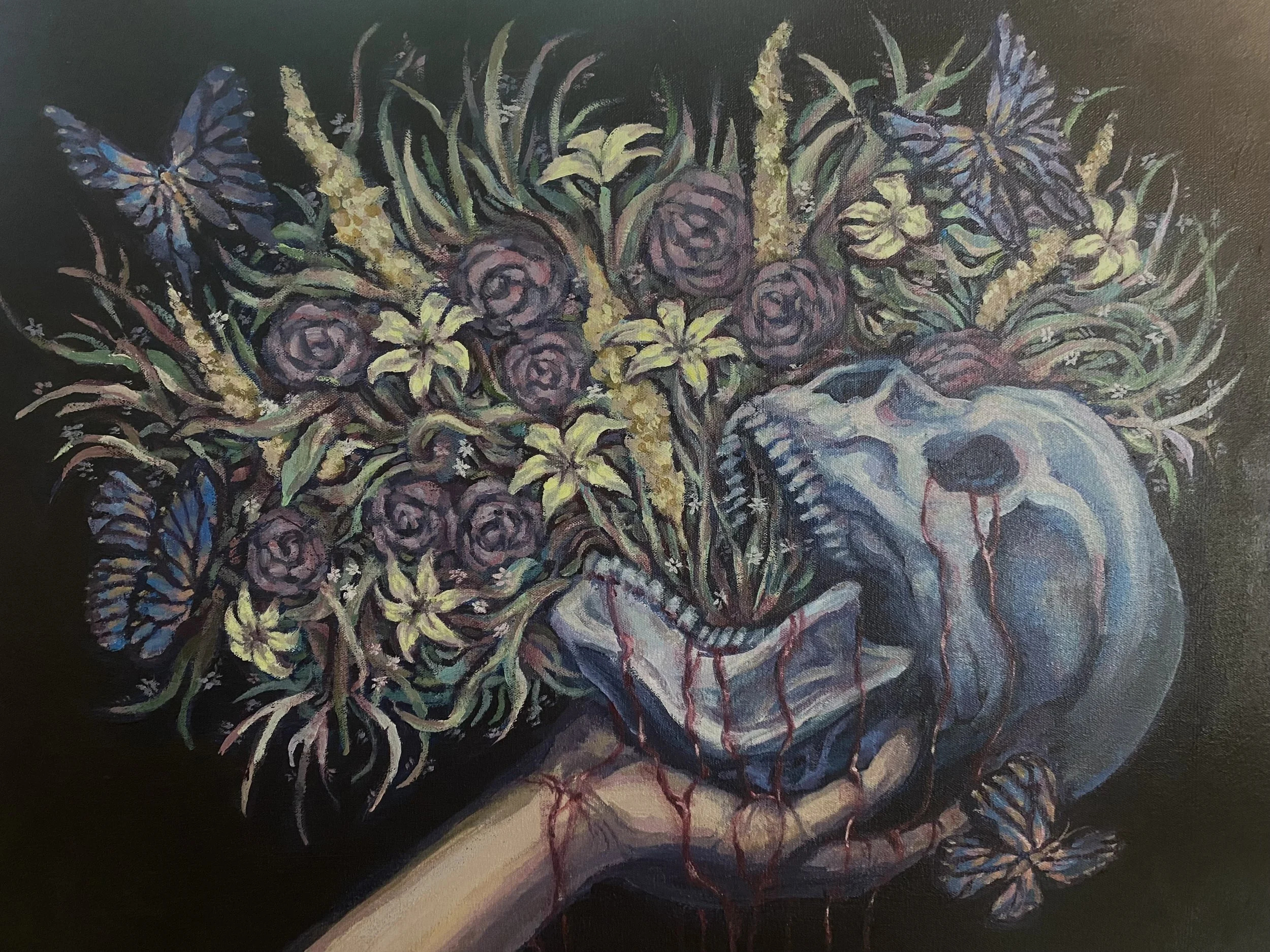 A human hand holding a skull with blood and growth emitting from the top of the skull. Growing from the top of the skull are various flowers, roses, lilies, and foliage, with butterflies and vines around them.