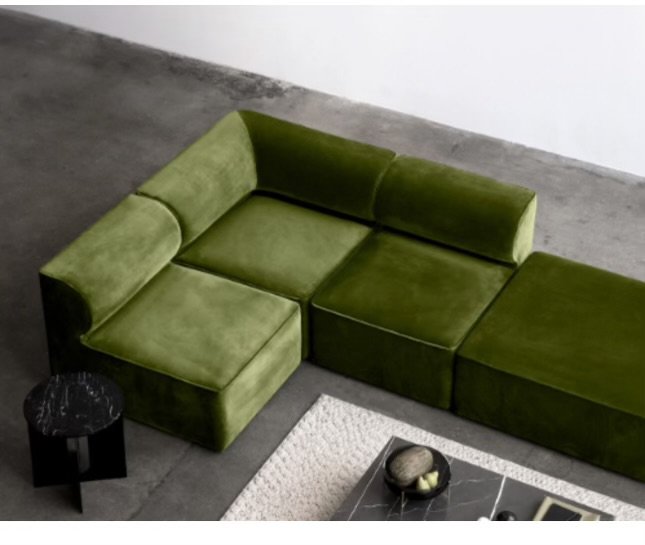 Green modular sectional sofa in modern living room with gray floor and beige rug