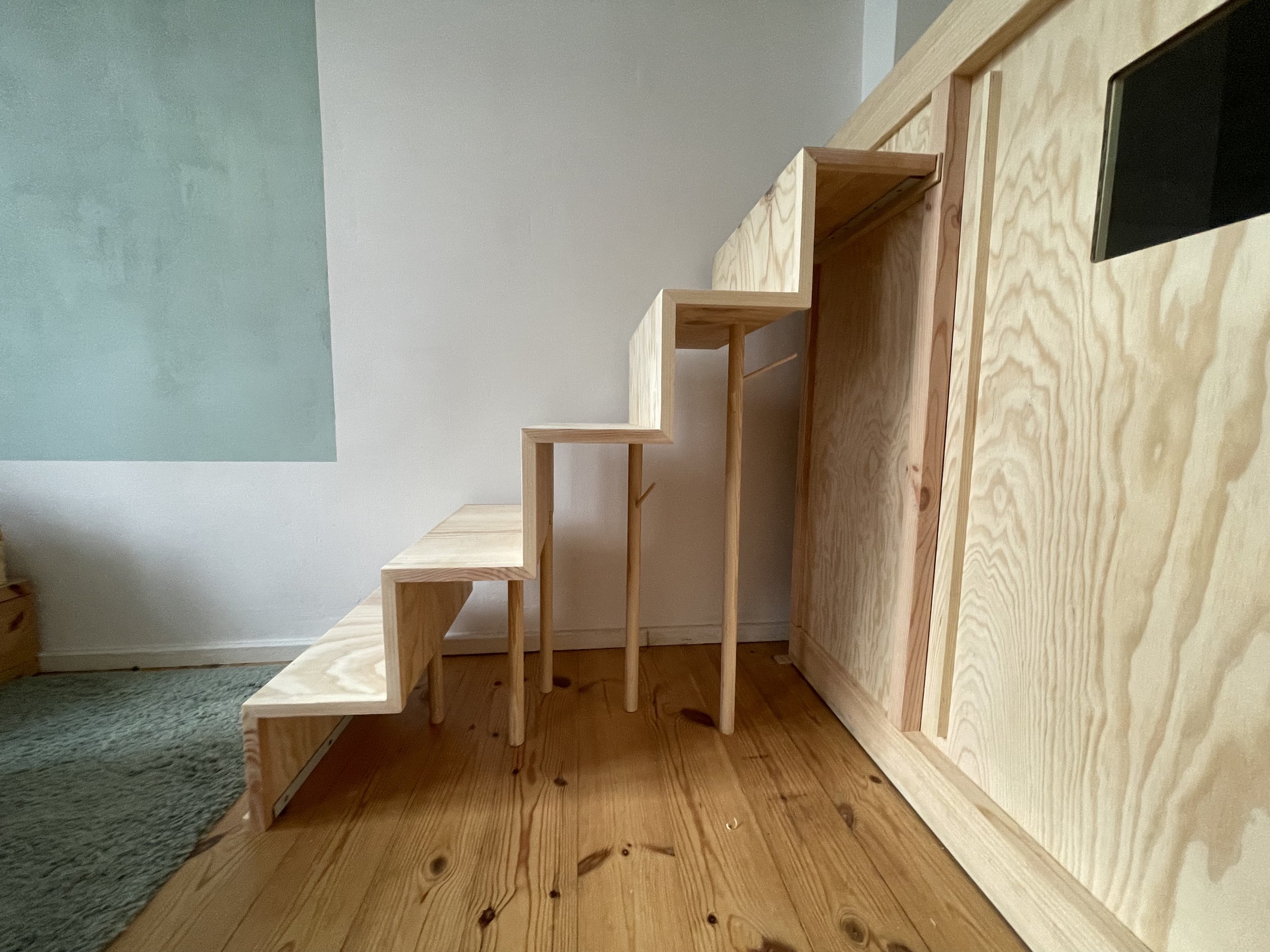 Holzstufen und -tafeln in modernem Design, Holz- und Teppichboden, heller Raum.