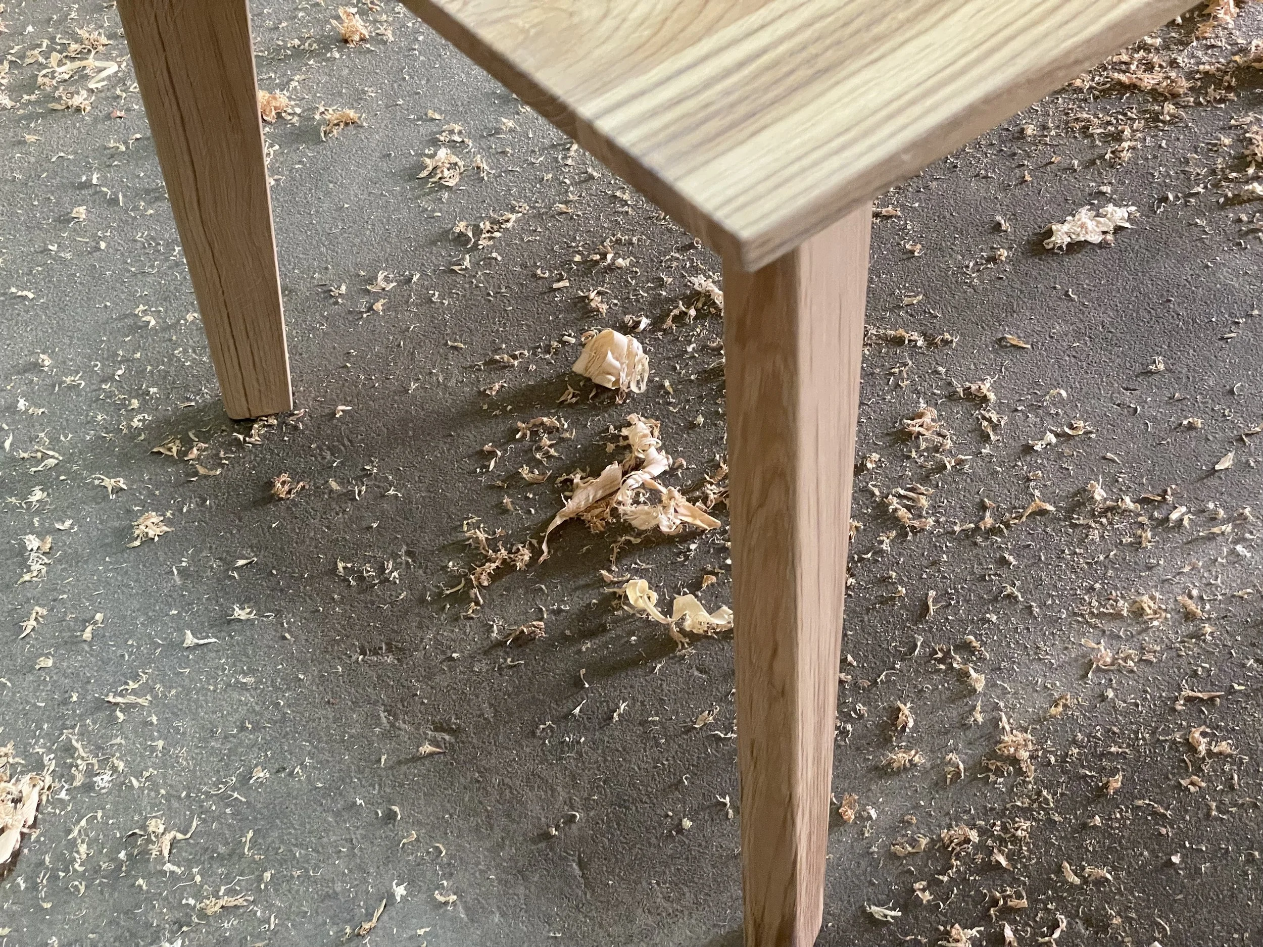 Boden mit Holzspänen unter einem Holztisch im Raum