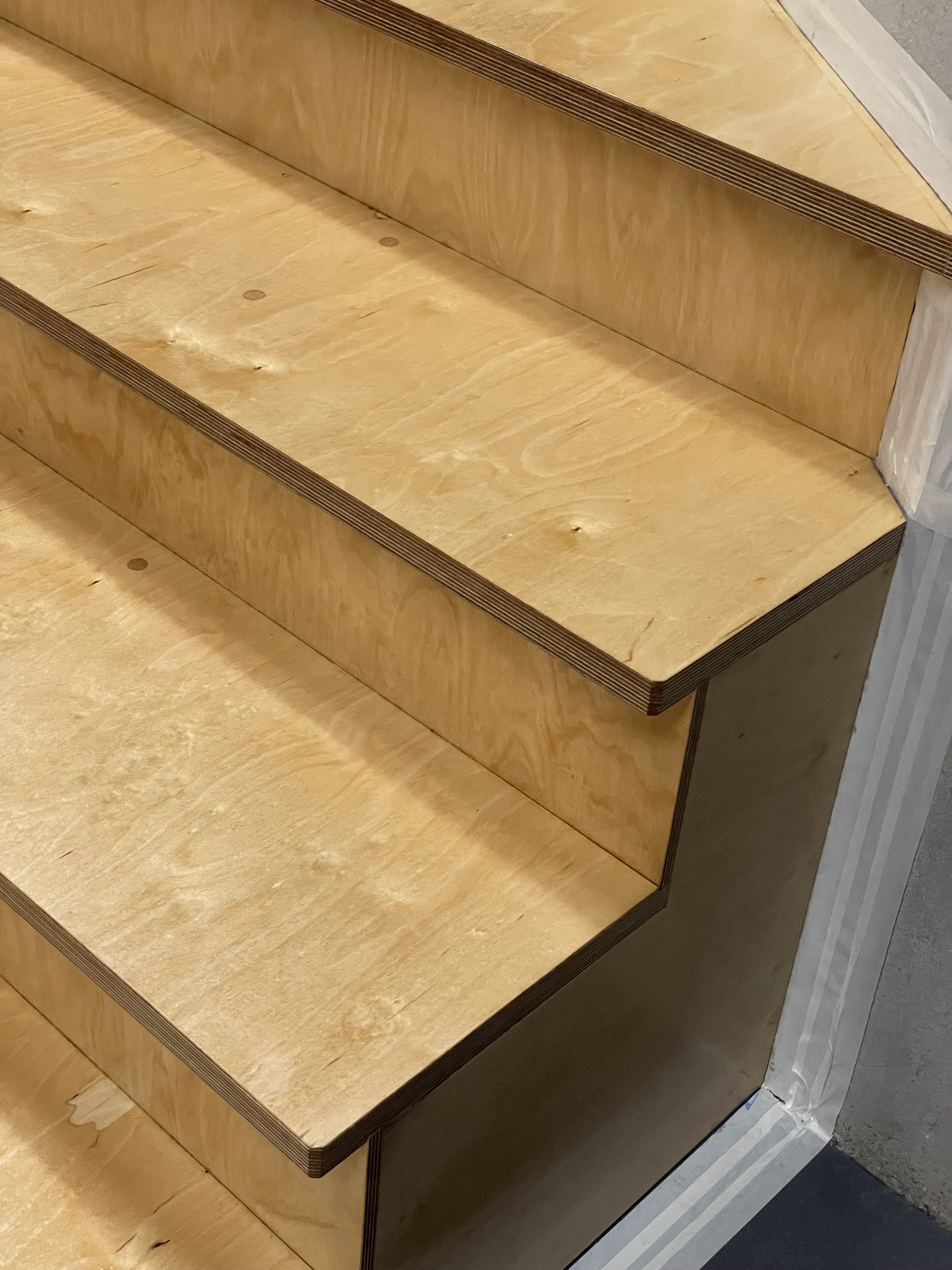 Holztreppe mit mehrstufigem Aufstieg, sichtbar in rohem, unbehandeltem Holz. Holzmaserung und Kanten Detail. Vorgehensweise beim Bau einer Treppe.