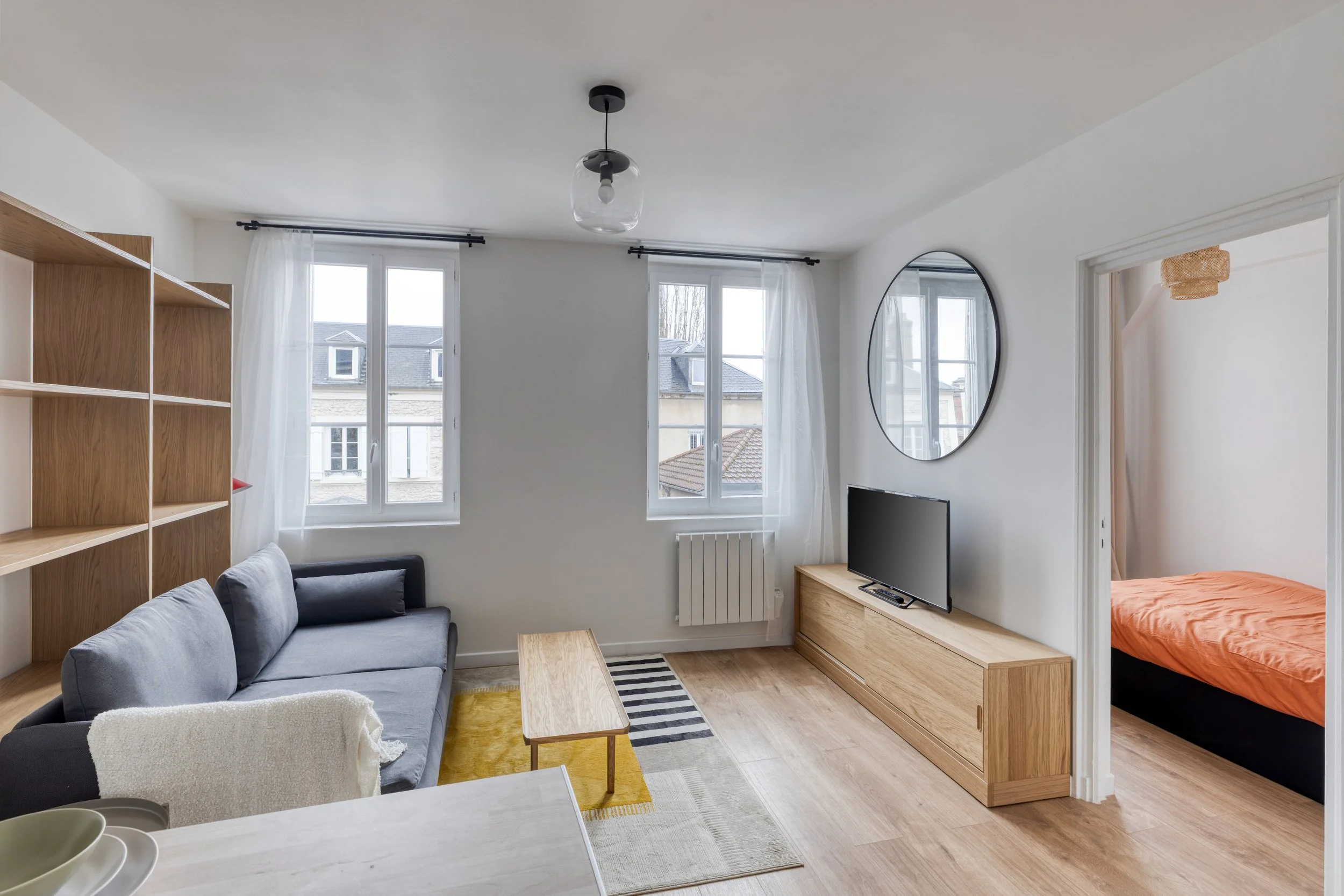 Salon lumineux rénové dans un T2 à Vernon, déco épurée avec bois clair et tons naturels.