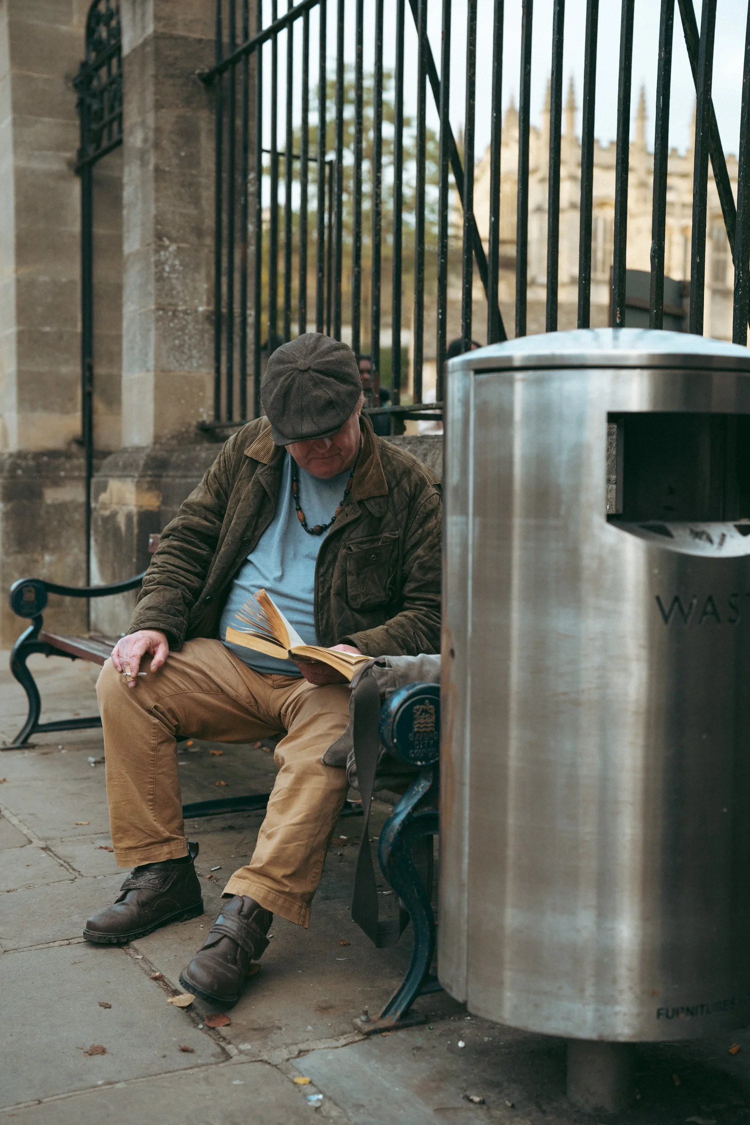 A man reading in soft golden light on the same bench, a different season.