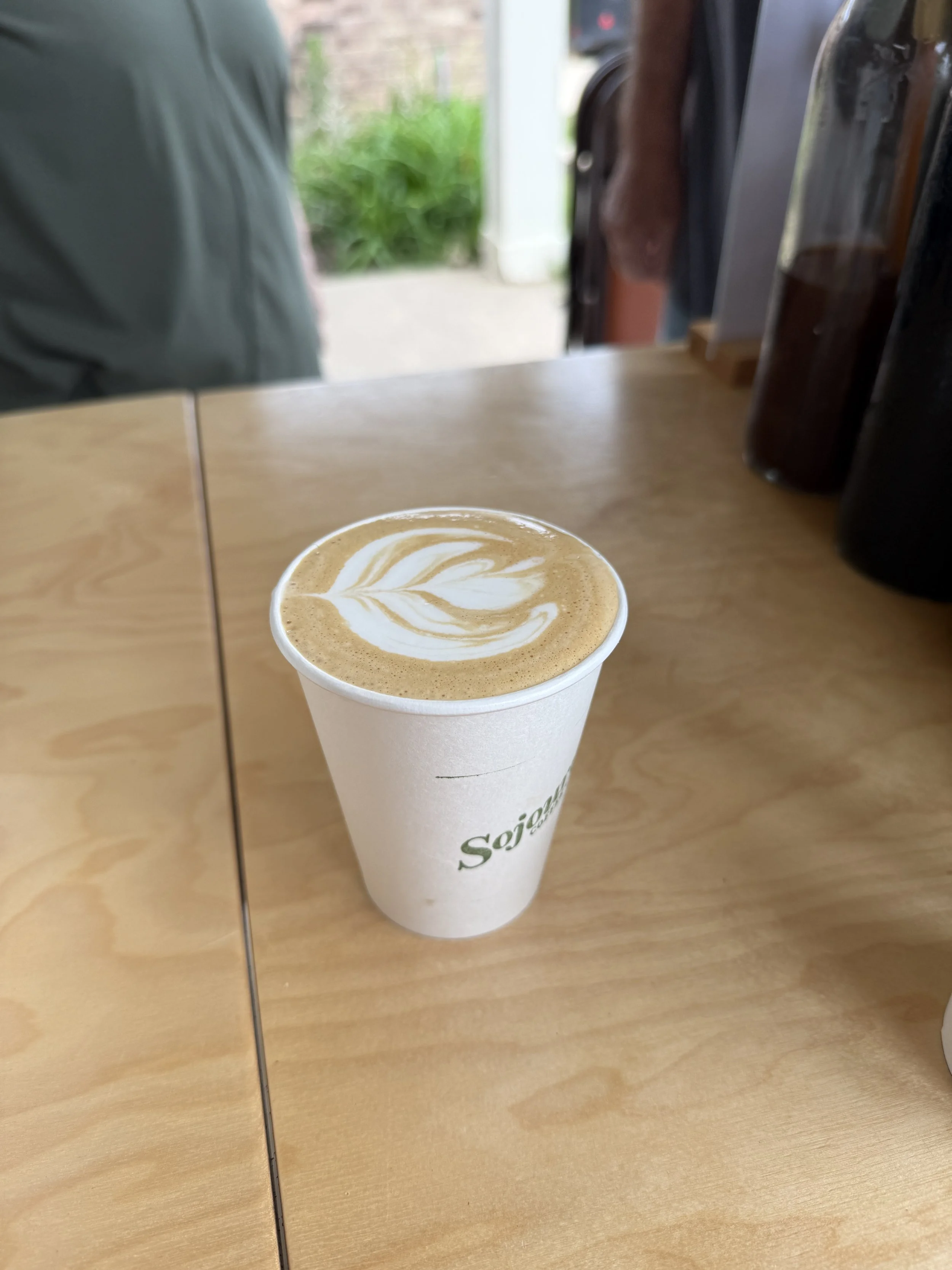 A cup of coffee with latte art on a wooden table at a coffee shop