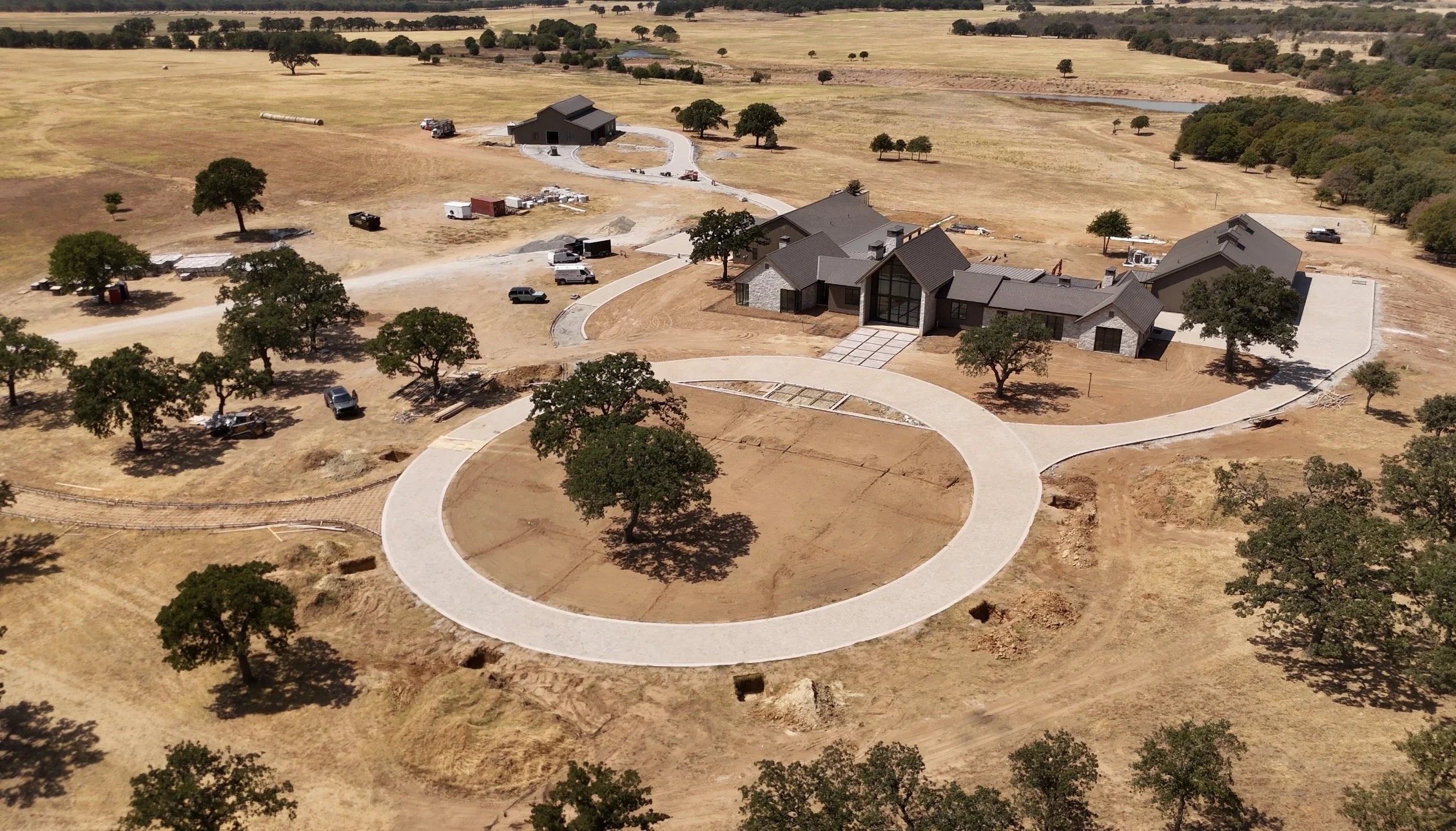 An aerial view of The Essex Ranch, with the newly installed entrance pads defining the approach before the surrounding landscape begins to take shape.