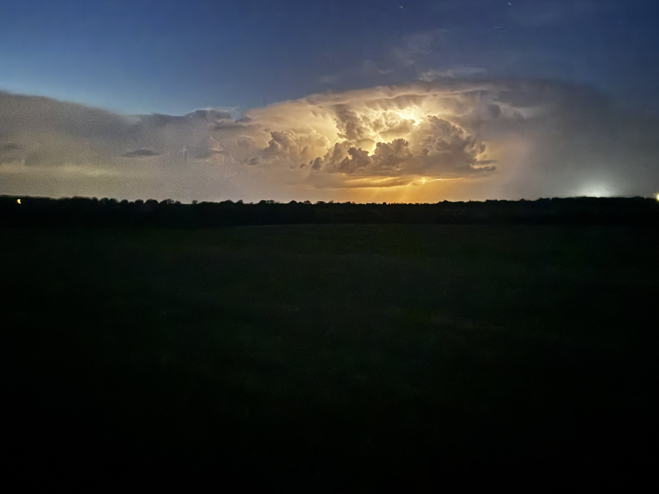 Storm Illuminated-
A powerful thunderstorm lights up the night sky with dramatic clouds and flashes of lightning on the horizon, showcasing the raw and awe-inspiring force of nature across the open fields.