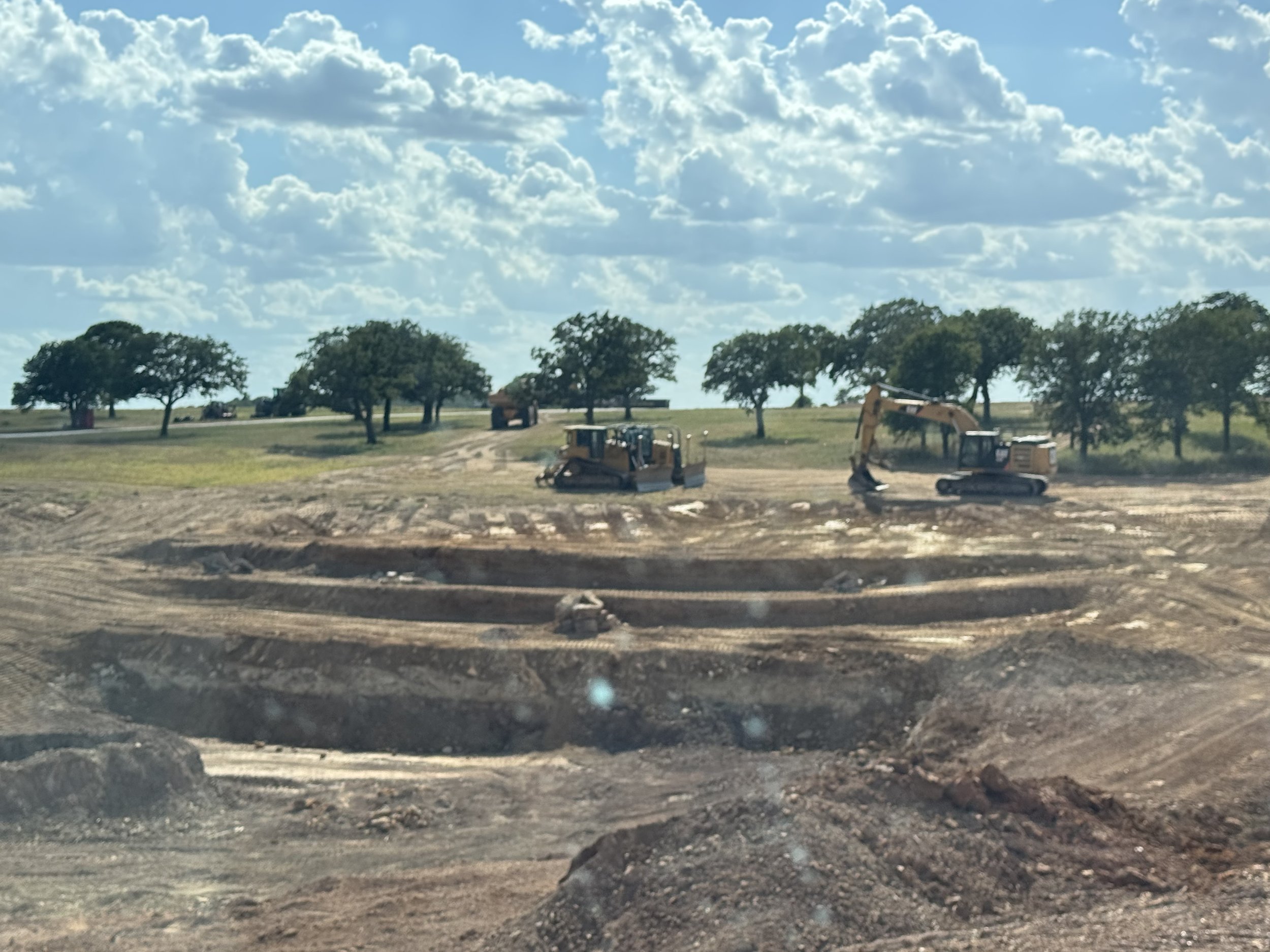 Another angle of the new lake at The Essex Ranch, still without water as excavation continues. This perspective showcases the depth and shape of the lake more clearly, with the surrounding land framing its borders. The expansive view highlights the c