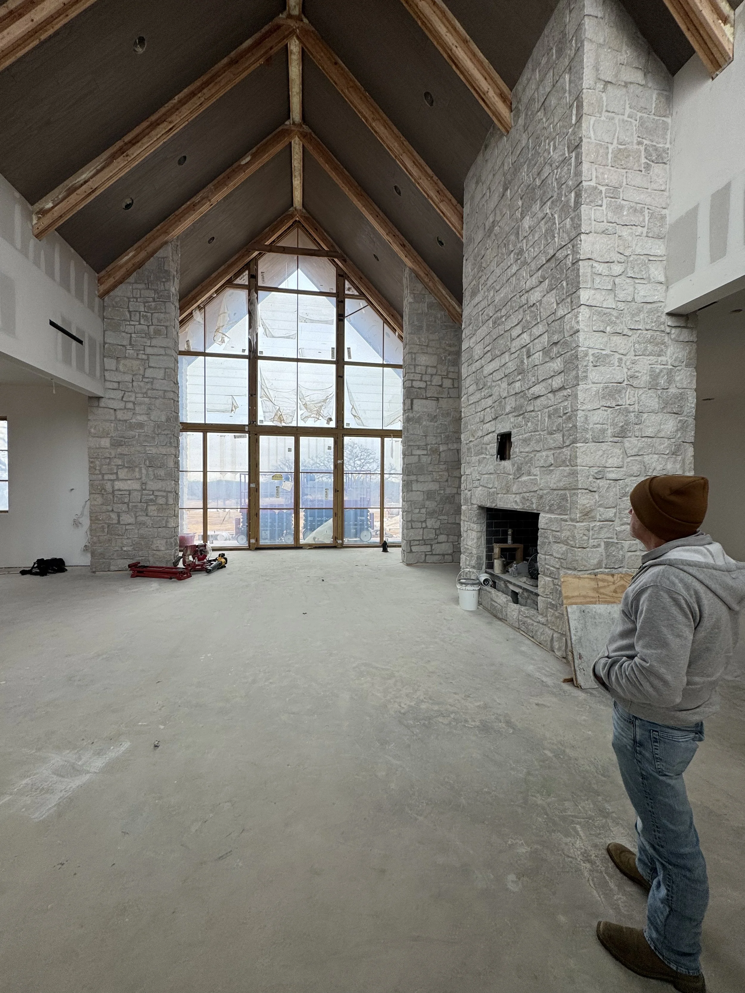 Vaulted great room at The Essex Ranch with stone fireplace under construction, January 2026