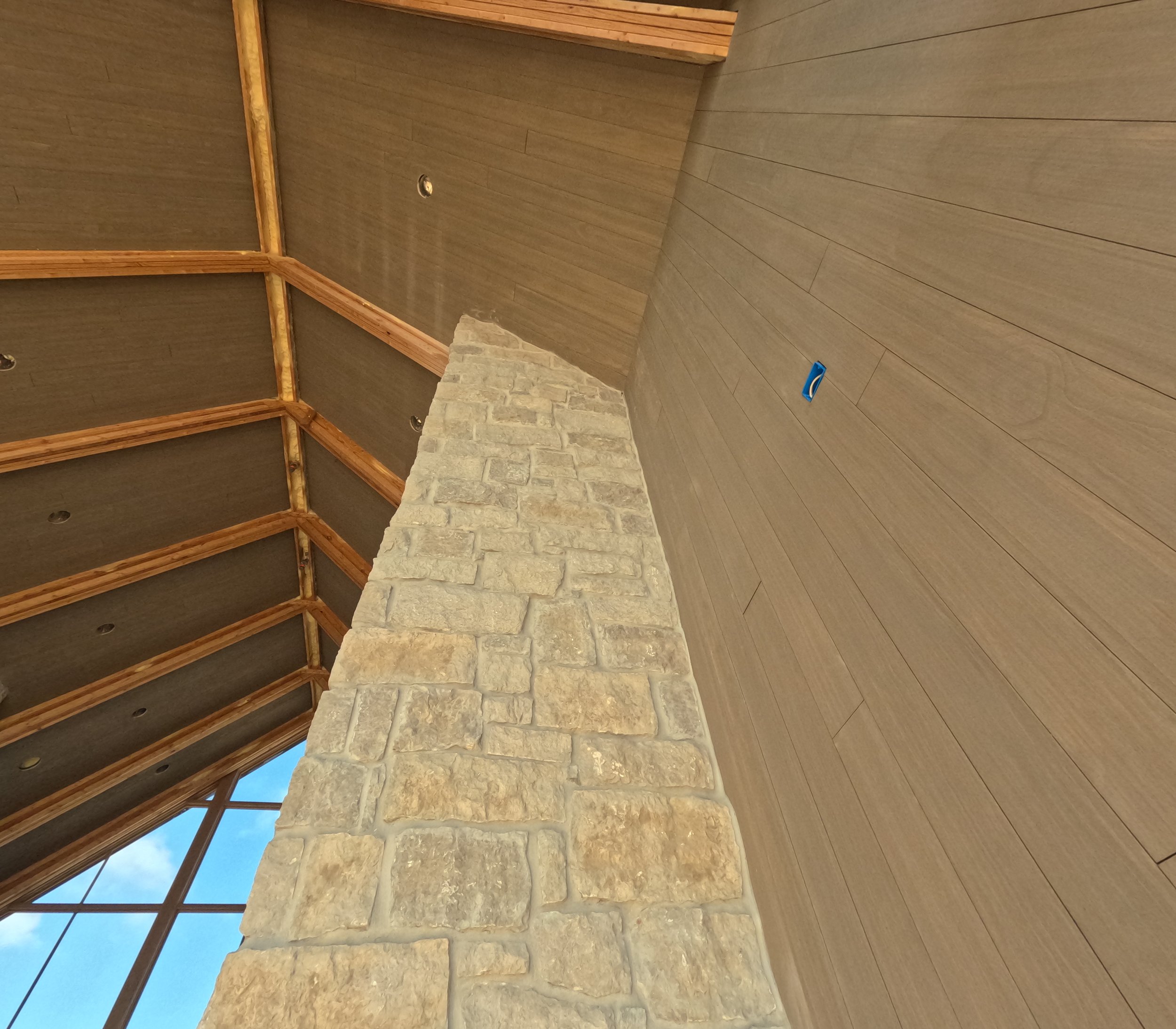 Stone wall, custom millwork, and vaulted ceiling details at the main house entry.