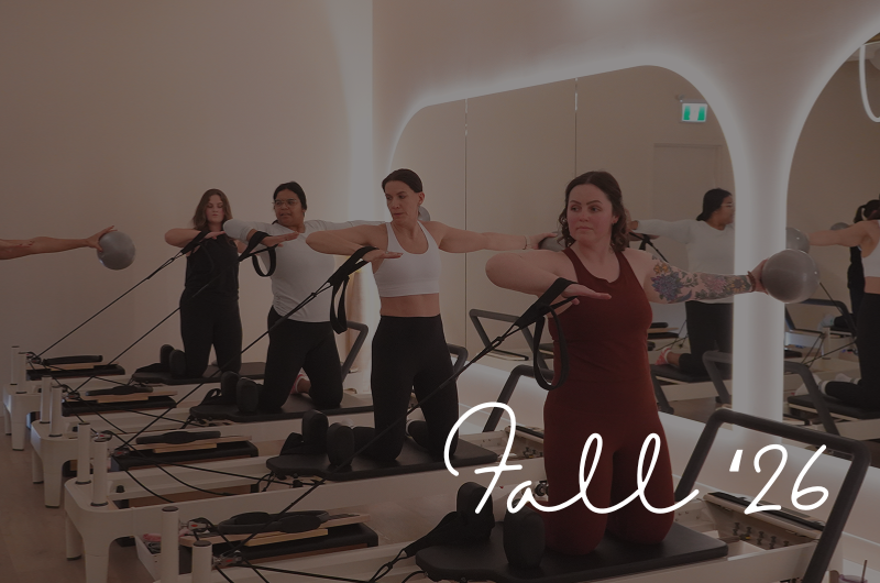 Women participating in a Pilates class using reformer machines in a modern studio