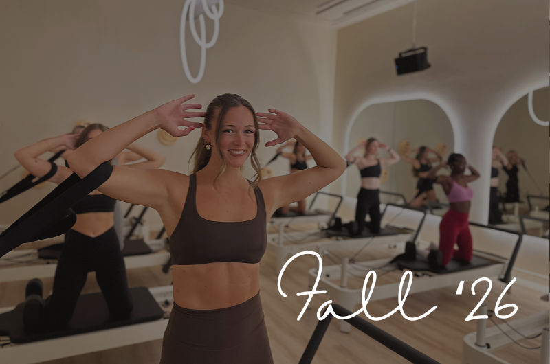 A group fitness class in a studio with women doing exercises on reformer machines, and a smiling woman in the foreground with her hands near her head. The text overlay reads 'Fall '26'.