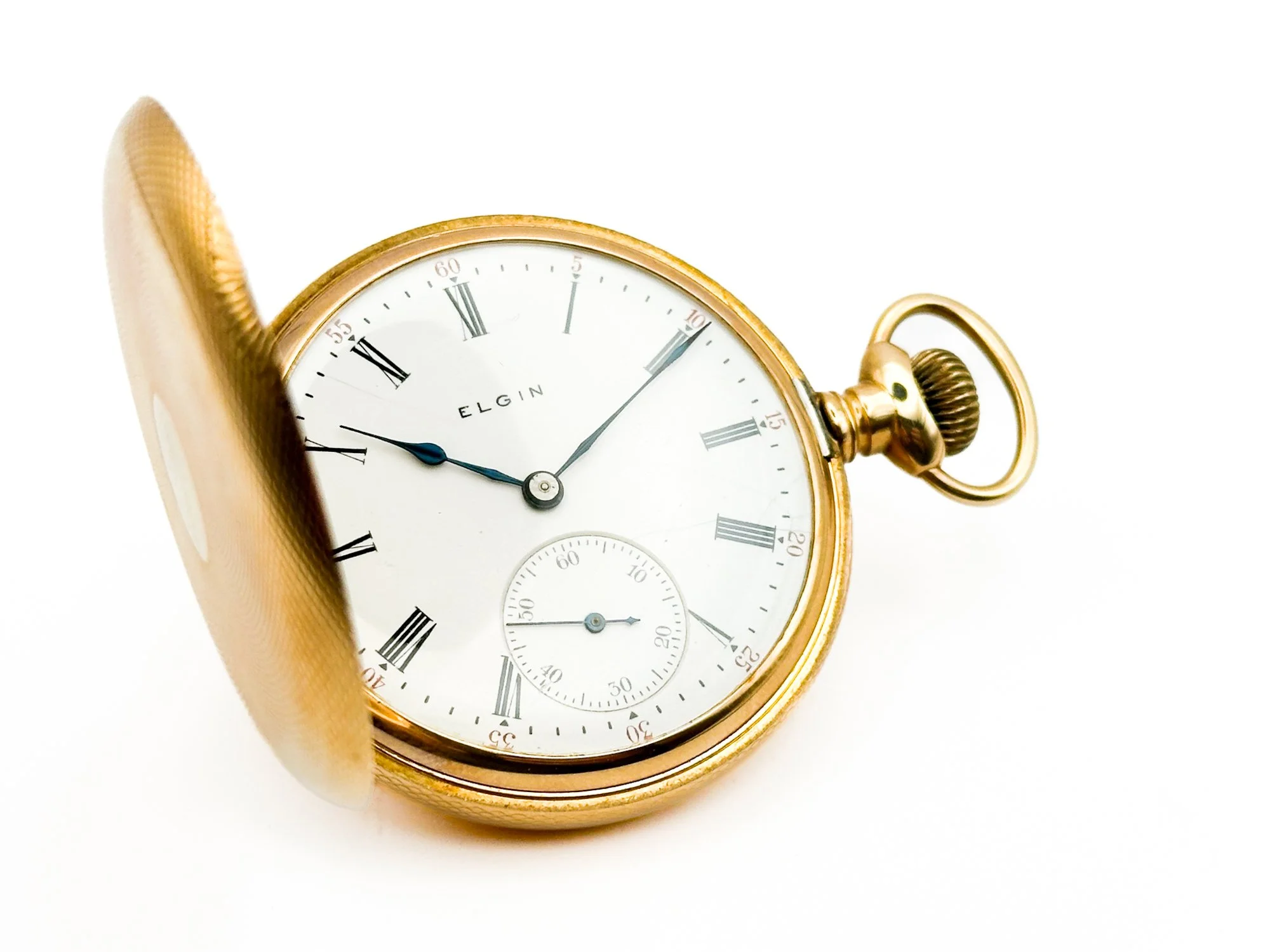 Gold pocket watch with white face, Roman numerals, partially open cover, and black and blue hands, on a white background.