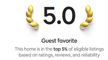 Home rating badge indicating a 5.0 guest favorite status, with gold laurel wreaths on each side, signifying top 5% of eligible listings based on ratings, reviews, and reliability.