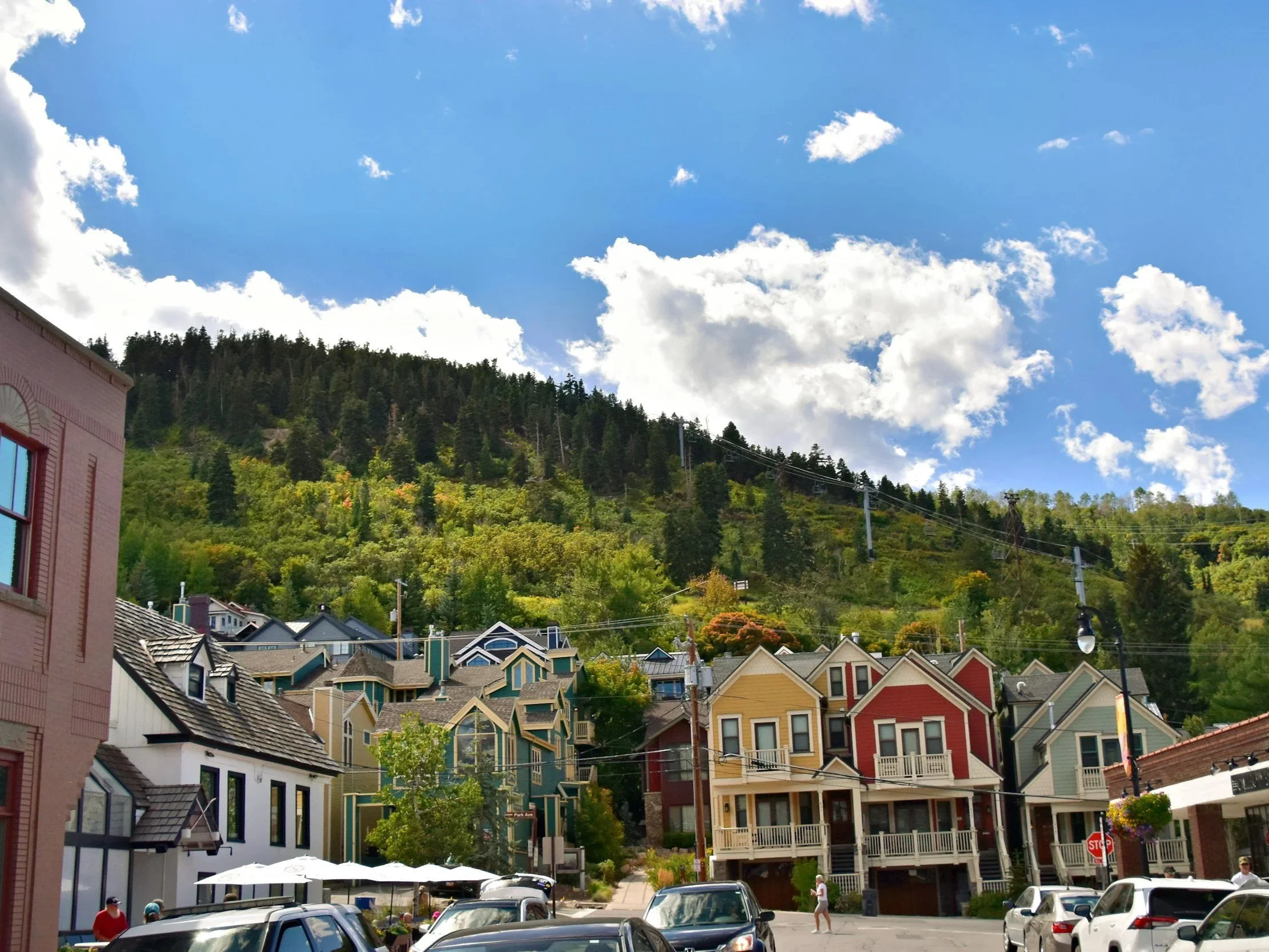 Colorful houses with a mountain and cloudy blue sky in the background.