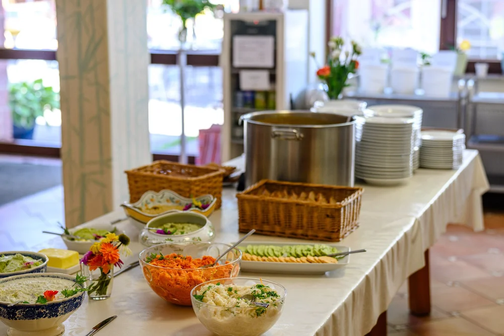 Buffet im Speisesaal mit Salaten, Brot und Töpfen