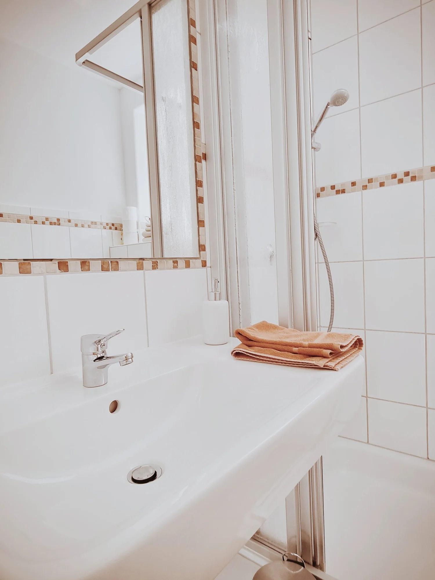 Badezimmer mit Waschbecken, bereitgelegten Handtüchern und Dusche
