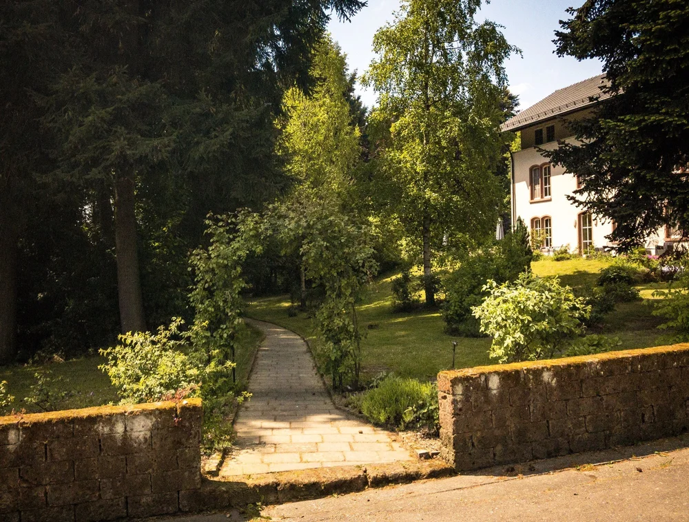 Gartenweg durch die Mauer hinauf zum Altbau
