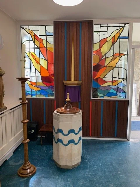 Picture of Font with stained glass window in background