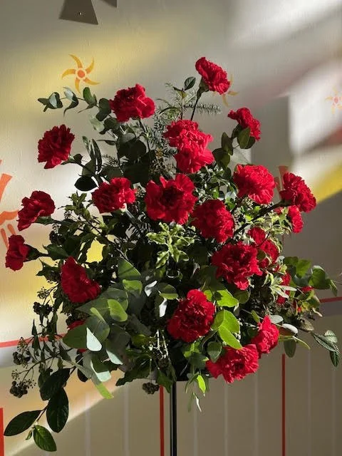 An arrangement of red carnations and greenery