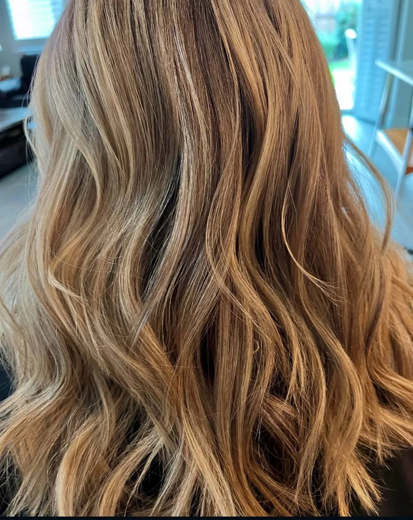 Close-up of wavy blonde hair with caramel highlights.
