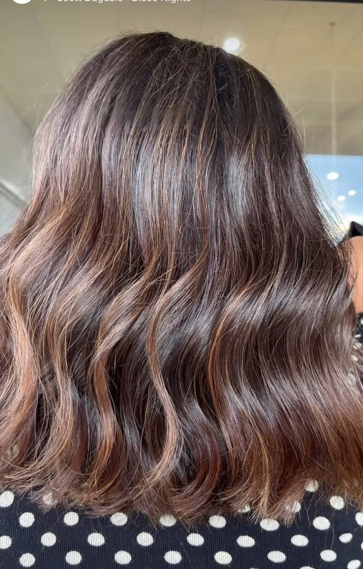 Close-up of wavy brown hair with light highlights.