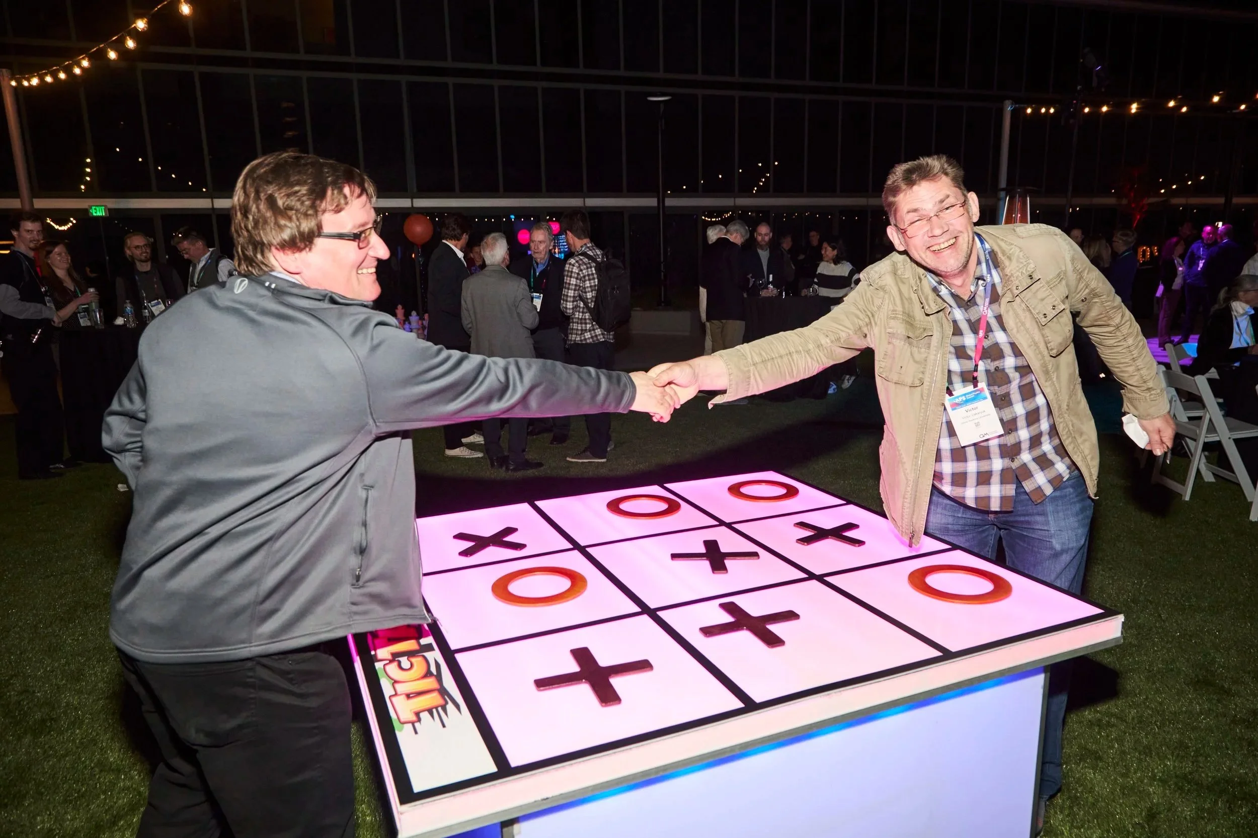 Doctors share a handshake after drawing a playful game of Tic-Tac-Toe at American  Physical Society International Year of Quantum Physics Reception. Everything Social Event Management 