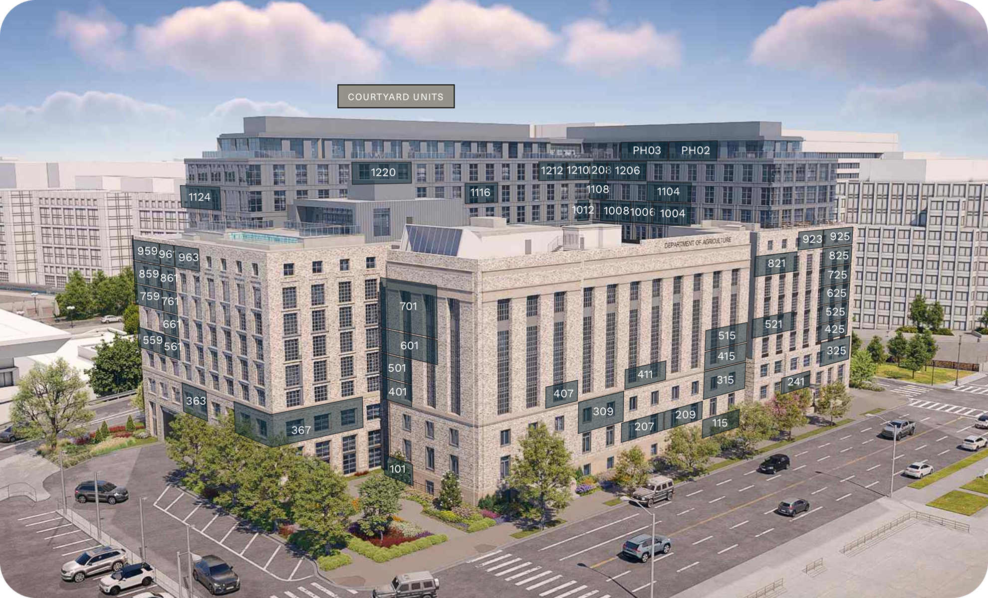 A large, modern multi-story building with labeled windows and sections, including a courtyard area and surrounding parking lot with cars, trees, and landscaped greenery.