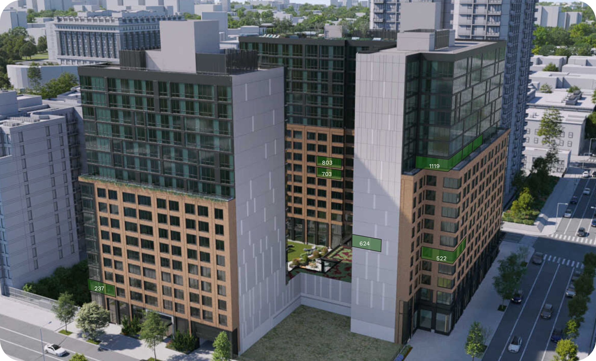 A modern multi-story building with a courtyard in the center, surrounded by neighboring high-rise structures, with trees and parked cars visible on the streets.