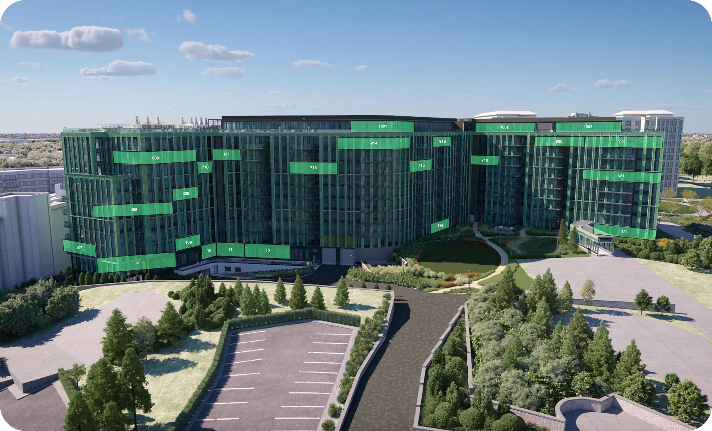 A large modern apartment complex with numbered labels on the building's facade, surrounded by landscaped gardens, parking lots, and trees under a partly cloudy sky.